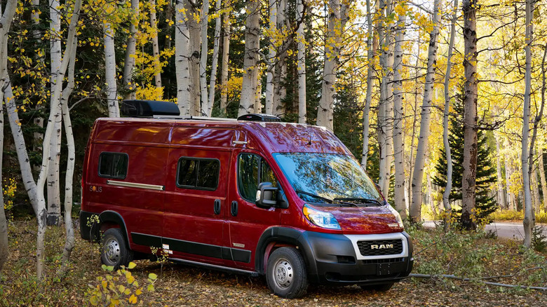 A Red Winnebago solis for the 2025 model year parked in a forest