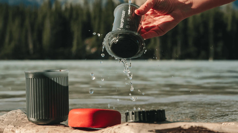 The AeroPress Go taken apart and being cleaned in the wilderness.