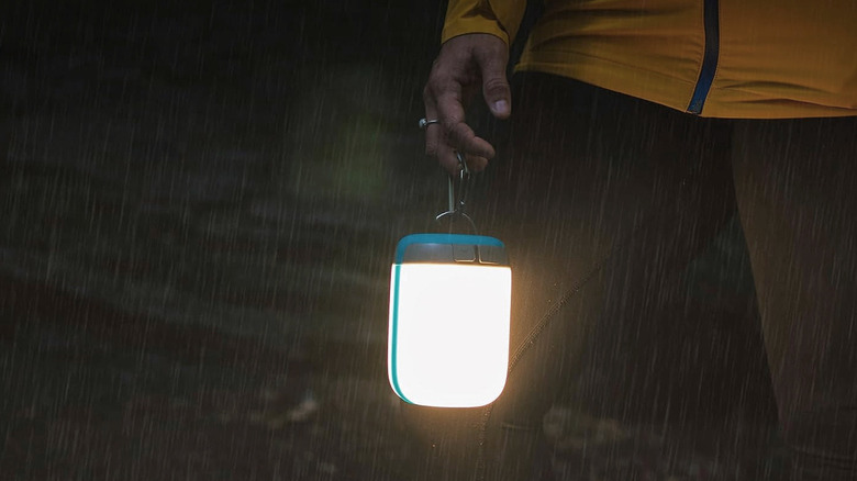 The BioLite AlpenGlow 500 being carried in the rain.