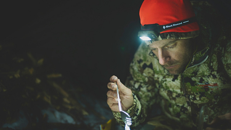 A camper lighting up his meal with the Black Diamond Spot 400-R.