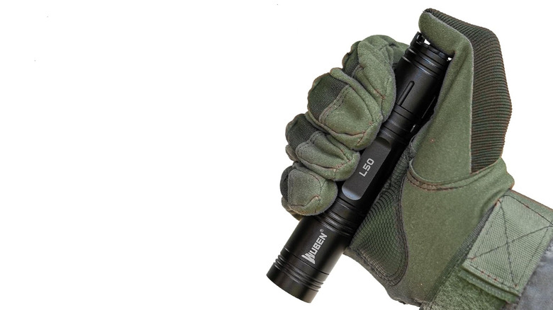 A gloved hand holding the Wuben L50 Flashlight.
