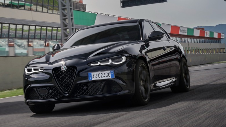 a black Alfa Romeo Giulia on a racetrack