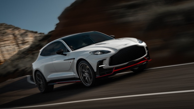the Aston Martin DBX driving quickly on a curve on the road