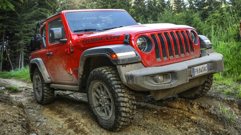 a red two-door Jeep Wrangler Rubicon driving offroad