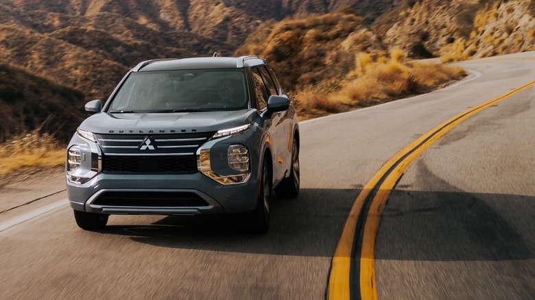 a Mitsubishi Outlander driving on a winding country road