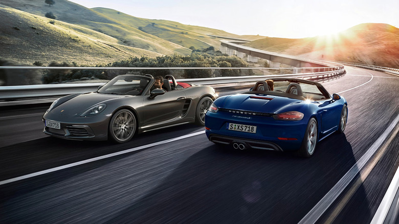 Two Porsche 718 Boxsters passing each other on a country highway