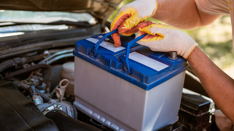 Someone replacing a car battery