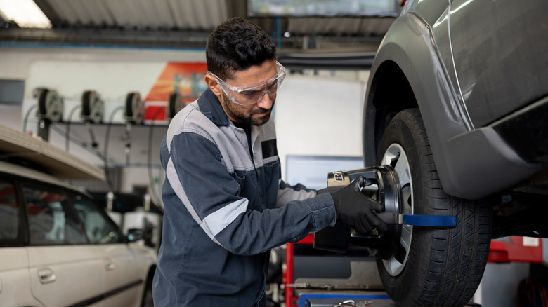 Mechanic inspecting car tires in a shop