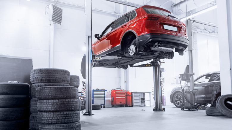 Car inside of a mechanic's shop receiving maintenance