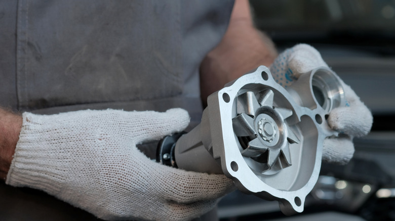 Mechanic holding a new water pump