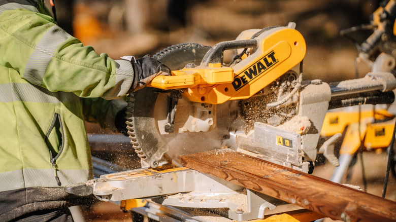 cutting a board with DeWalt miter saw