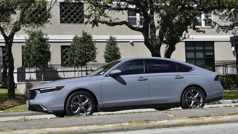 A grey Honda Accord driving along a paved road