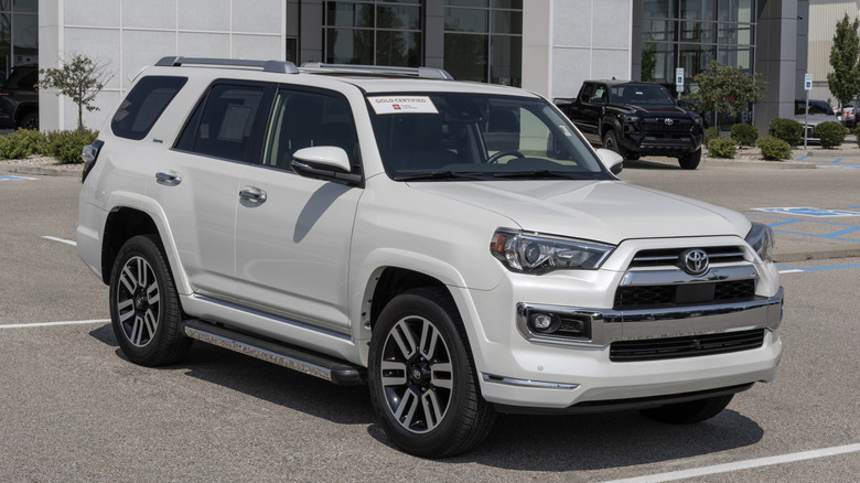 A white Toyota 4Runner in front of a Toyota dealership