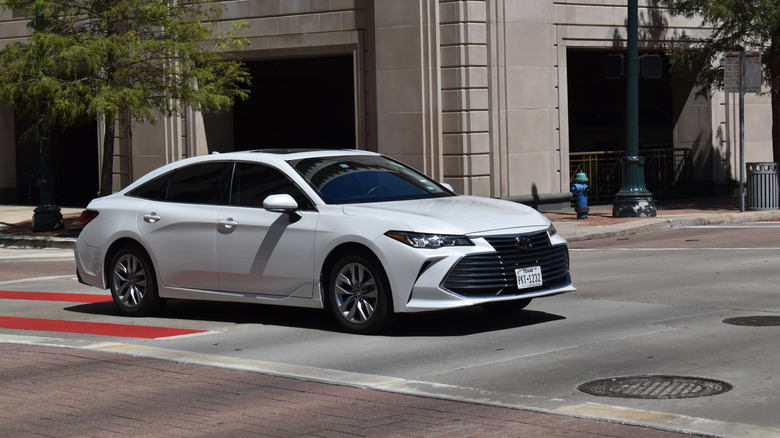 A white 2022 Toyota Avalon passing through an intersection
