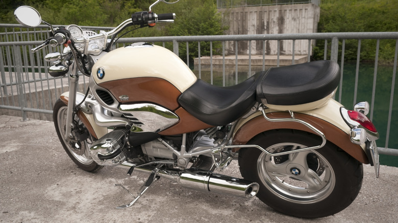 A 2003 BMW R1200C finished in cream and brown, parked outside next to a railing.