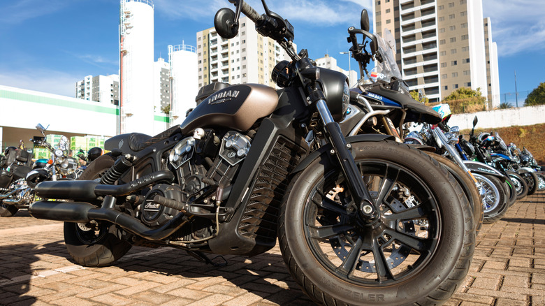 A black Indian Scout motorcycle in the Bobber finish parked outside during an exhibition.