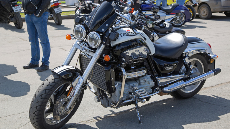 A silver and black 2023 Triumph Rocket III Roadster chopper motorcycle parked outside.
