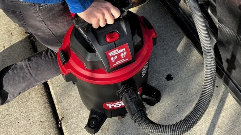 Person using wet/dry vacuum