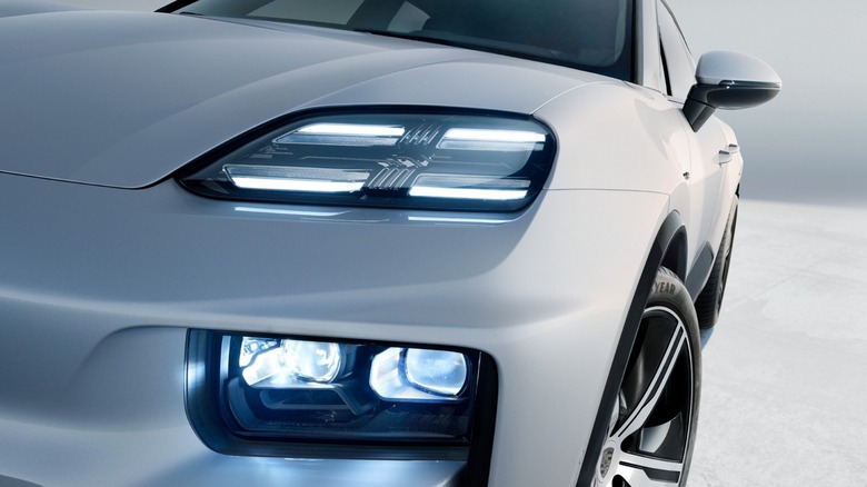 Close-up of the front end of a white Porsche Macan, highlighting its distinctive HD Matrix headlights.