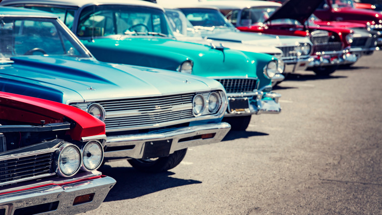 A lineup of colorful classic cars at a car show.