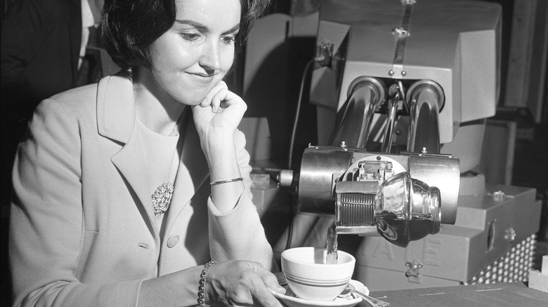 A Unimate robot pouring coffee for a woman in 1967