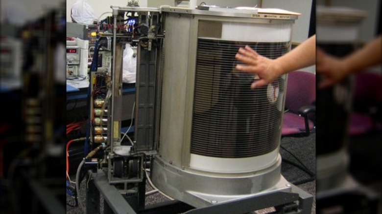 A hand gesturing at the IBM 350 RAMAC, the world's first computer hard disk drive