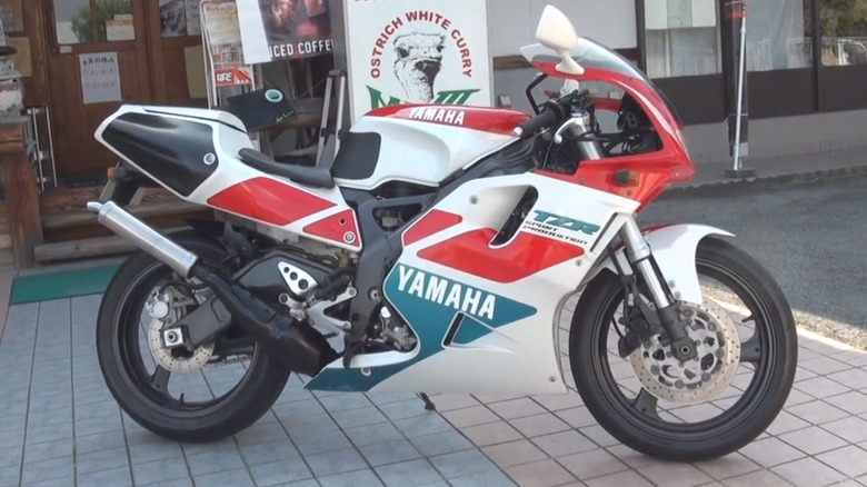 An image of a TZR250R SP being admired in front of a restaurant known for its ostrich white curry.