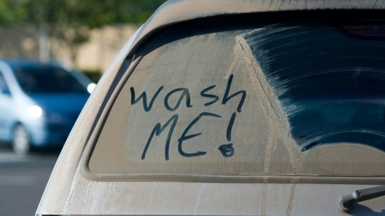 car with wash me written in the window grime