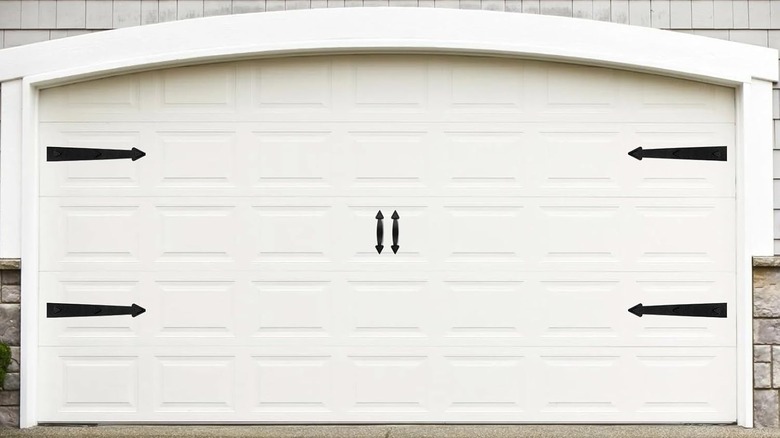 A white garage door with black decorations.
