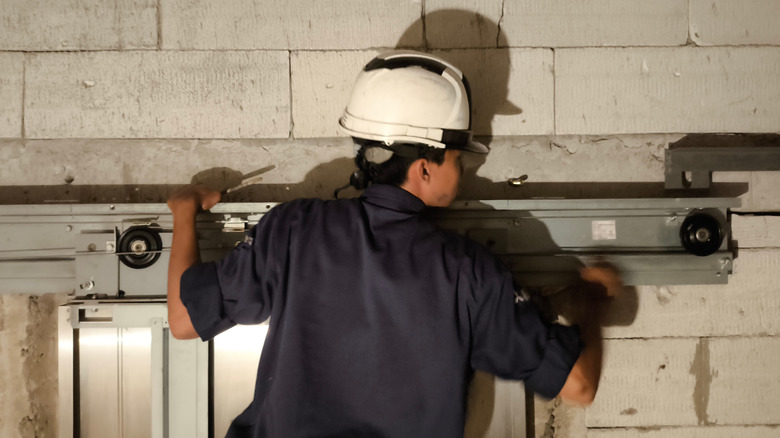 Worker installing garage door tracks.