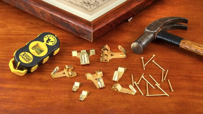 A picture frame with hanging hardware next to a C.H. Hanson magnetic stud finder