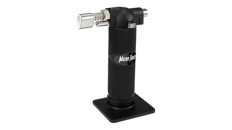 A small, black butane torch on white background.