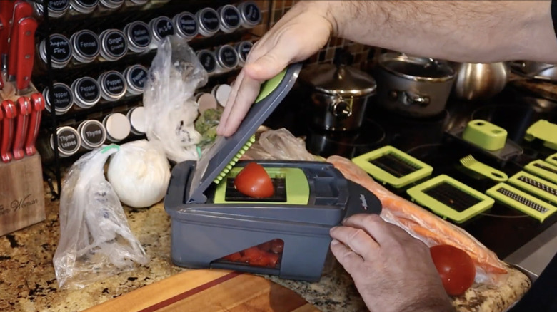 A person using the Mueller Mandoline Slicer to slice potatoes