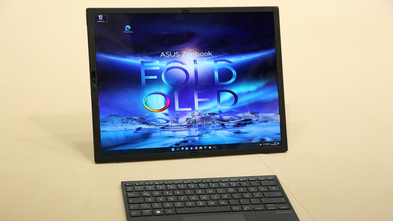 An Asus Zenbook 17 Fold Laptop computer sitting on a beige desk in its fully open configuration at a trade show.