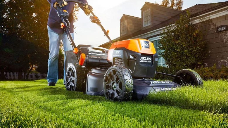 A person mowing a lawn with an 80V Atlas lawn mower.