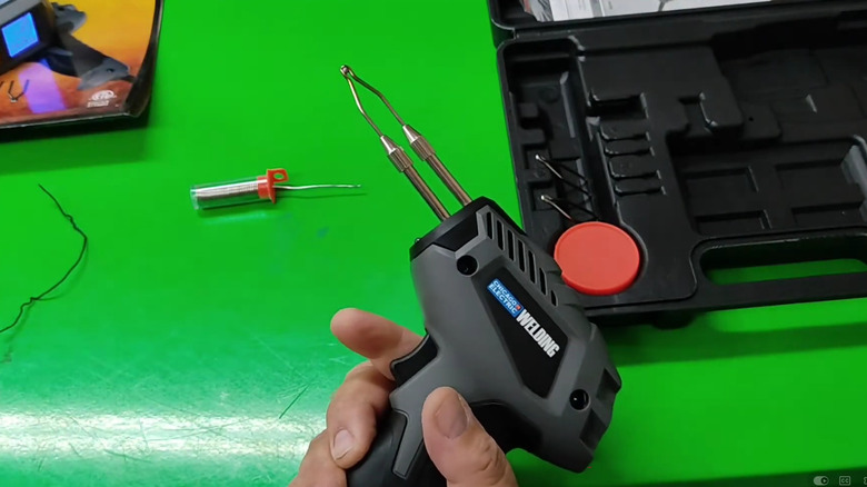 A person holds the Chicago Electric 100W Soldering Gun in hand.