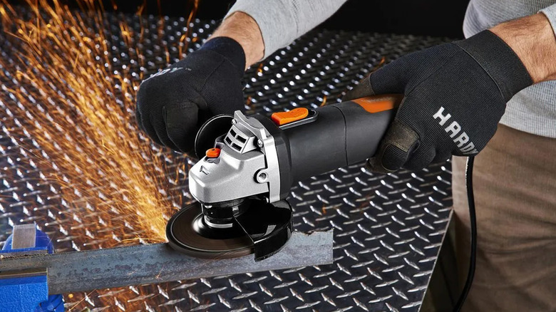 A person using an angle grinder to grind a piece of metal.
