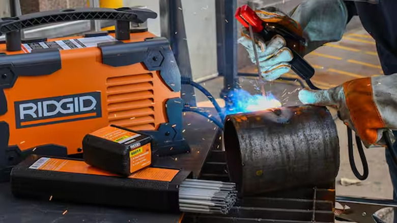 A worker welding with a Ridgid TIG welder