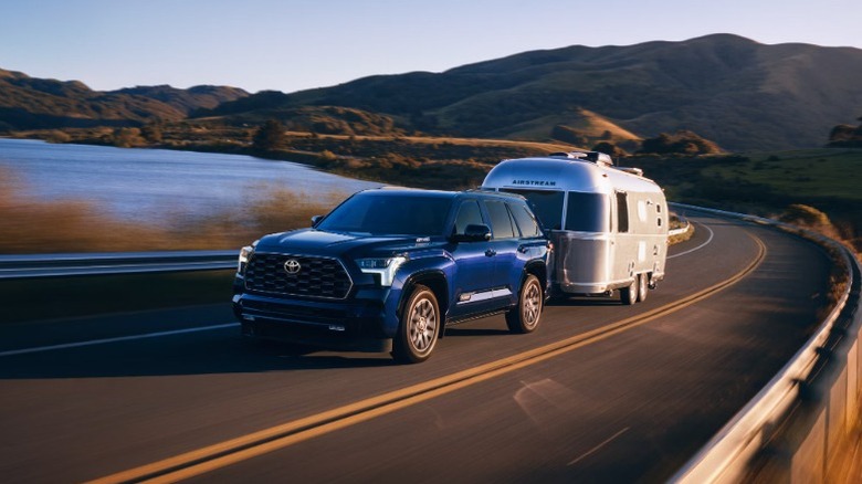 A blue 2025 Chevrolet Tahoe attached to a trailer