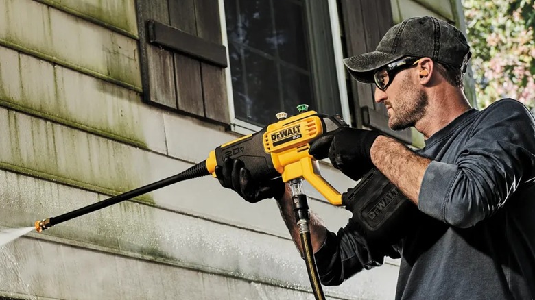 spraying house siding with power cleaner