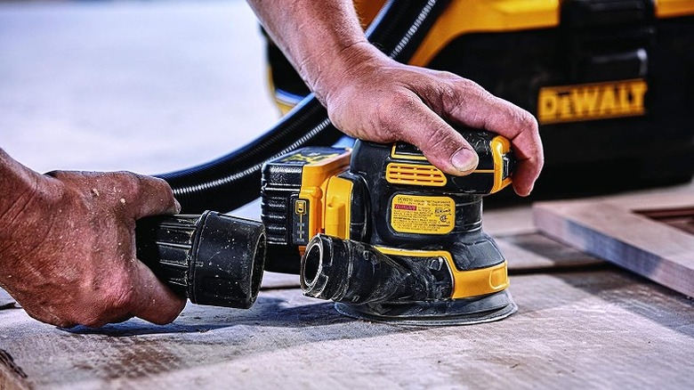 Attaching a vacuum hose to DeWalt orbital sander