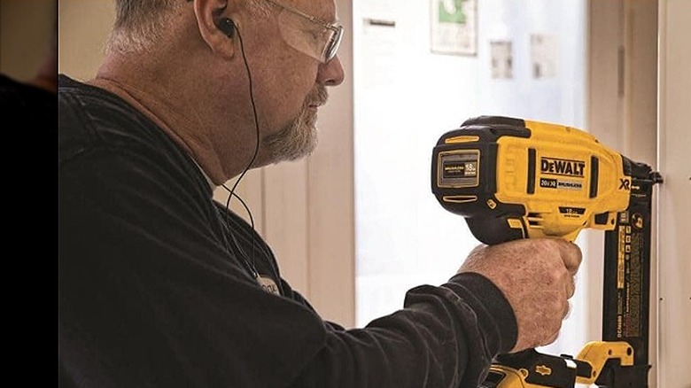 Man using brad nailer indoors