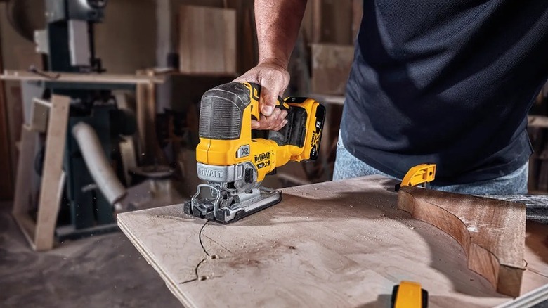 Man using a jig saw to create decorative cuts on wood
