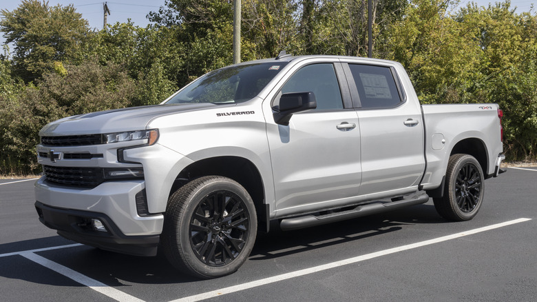 A previous generation Silverado 1500 in silver by Chevrolet parked at the side of a road.