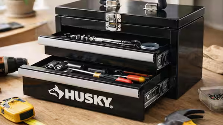 A black Husky mini toolbox with tools in it.