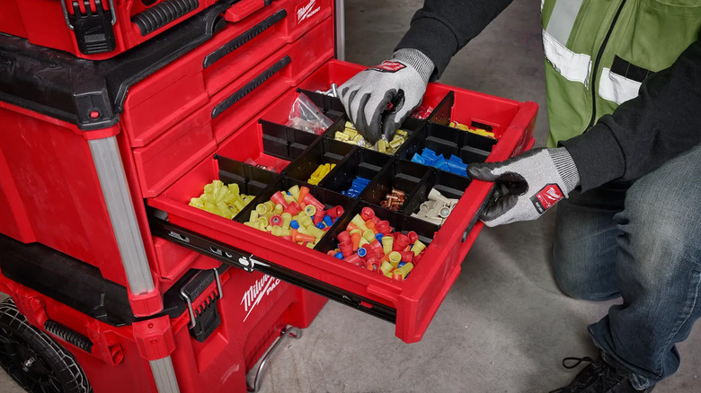 A person opening a Packout toolbox to get parts.