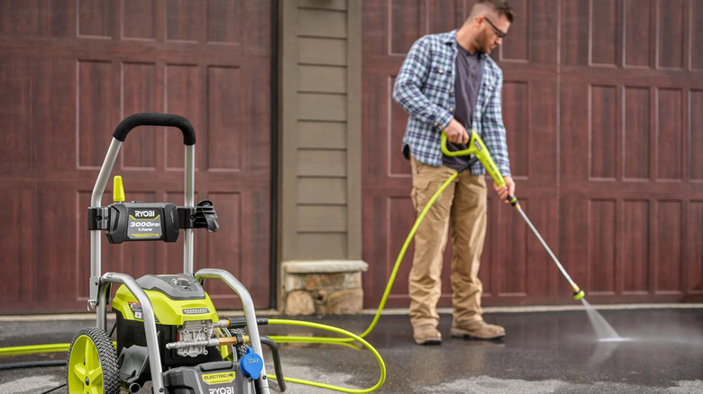 A man power washing his driveway