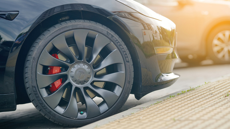 A Tesla 3 tire parked close to a curb
