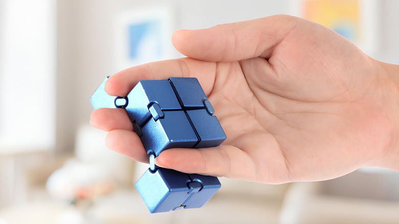 Person holding a cube sensory fidget toy