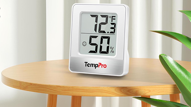 White digital hygrometer/thermometer on top of a round table